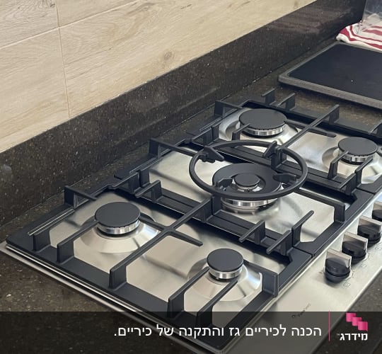 כיריים גז עם ארבעה מבערים וכפתורי שליטה